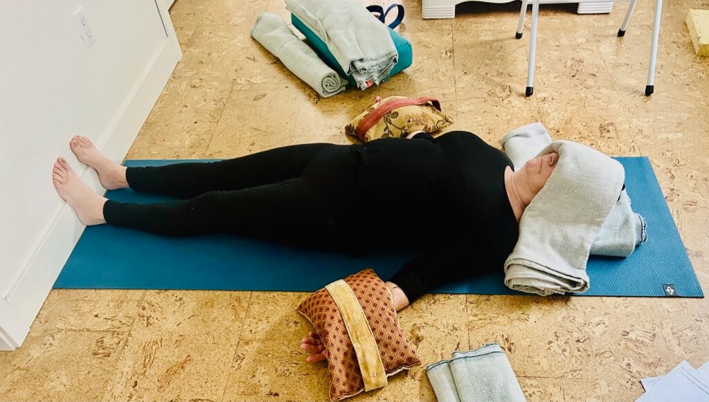 A woman practices savasana